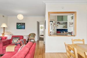 a living room with a red couch and a table at Beach Bach in Point Lonsdale