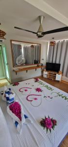 a bedroom with a bed with flowers on it at White Sand Himandhoo in Himandhoo 