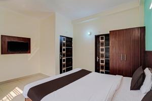 a bedroom with a bed and a television in it at Super OYO Golden Imperial Near PVR Ansal Plaza Greater Noida in Greater Noida