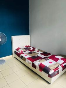 a bed with a quilt on it in a room at Abang payung sierra perdana in Masai