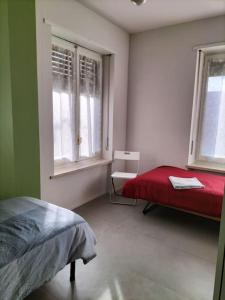 1 Schlafzimmer mit einem roten Bett und 2 Fenstern in der Unterkunft Villa Mirabella, il bosco in Città. in Turin