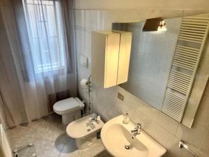 a bathroom with a sink and a toilet and a mirror at La tana del Diego in Casalecchio di Reno