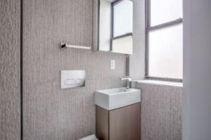 ein Bad mit einem Waschbecken und einem Fenster in der Unterkunft Lovely 3 Bedroom Apartment in New York