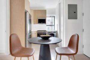 a small kitchen with a table and two chairs at Lovely 3 Bedroom Apartment in New York