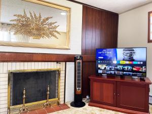 sala de estar con chimenea y TV en Entire Home in Buffalo - 6 Guests 3 Bedroom 1 Bath - Convenient Location 7 mins from Airport en Buffalo