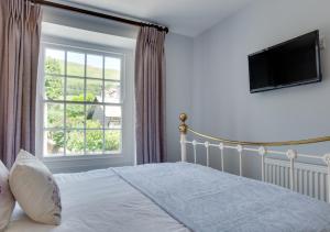 a bedroom with a bed and a large window at Memories Cottage in Milnthorpe