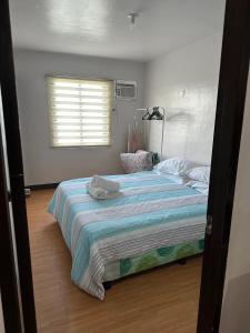 a bedroom with a large bed with a striped blanket at Cebu City 2 Bedroom Condo Unit-WIFI-A/C-Hot Shower (U404) in Cebu City