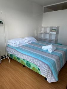 a bedroom with a large bed with a striped blanket at Cebu City 2 Bedroom Condo Unit-WIFI-A/C-Hot Shower (U404) in Cebu City