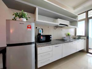 une cuisine avec des armoires blanches et un réfrigérateur dans l'établissement Shaftsbury 1 BR w Netflix Wi-Fi, à Cyberjaya
