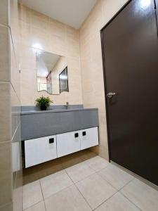 La salle de bains est pourvue d'un lavabo, d'un miroir et d'une porte. dans l'établissement Shaftsbury 1 BR w Netflix Wi-Fi, à Cyberjaya