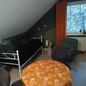 een slaapkamer met een bed en stoelen en een tafel bij Ferienhaus Waldperle Harzblick in Wernrode
