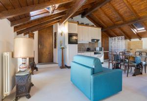 Il comprend un salon avec un canapé bleu et une cuisine. dans l'établissement Casa Dell' Artista, à Sala Comacina