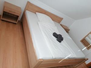 un oso de peluche negro sentado en una cama en Ferienwohnungen Ryck Blick, en Greifswald