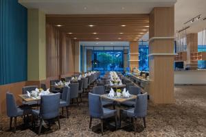 a long dining room with tables and chairs at ASTON Inn Tasikmalaya in Tasikmalaya