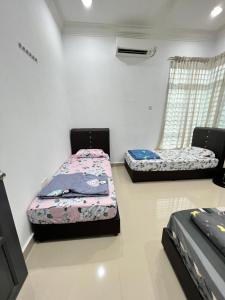 2 camas en una habitación con 2 ventanas en EMPIRE HOMESTAY PAKA ROOM 3A, en Paka