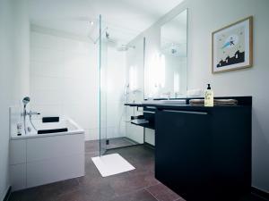 a bathroom with a shower and a sink and a tub at ipartment Frankfurt City Centre in Frankfurt/Main +30 photos