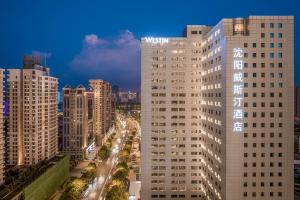 a view of a tall white building in a city at The Westin Shenyang in Shenyang
