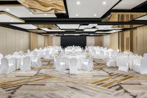 Cette grande chambre comprend des tables et des chaises blanches. dans l'établissement The Westin Shenyang, à Shenyang