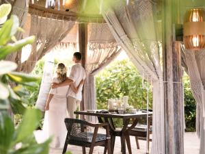 een bruid en bruidegom die voor een tafel staan bij The Nautilus Maldives in Baa Atoll