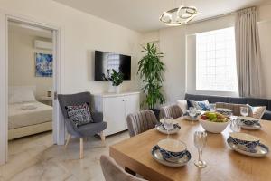 a dining room and living room with a table and chairs at New cozy apartments in Crete Coast with pool and dining area in Magnisía