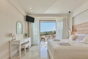 a white bedroom with a desk and a bed and a window at New cozy apartments in Crete Coast with pool and dining area in Magnisía +100 photos