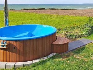 a hot tub in a field next to a beach at 8 person holiday home in Kalundborg in Kalundborg