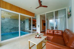 a living room with a couch and a swimming pool at Anantam Resort & Spa in Kasauli