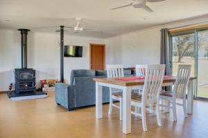 a dining room with a table and chairs and a couch at Kangarooby Cottage - A Peaceful Off-grid Escape 