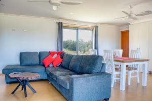 sala de estar con sofá azul y mesa en Kangarooby Cottage - A Peaceful Off-grid Escape, 