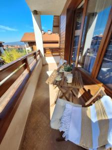 Cozy studio with balcony in 4-star hotel Saint Ivan Rilski, Bansko في بانسكو: شرفة على طاولة وكراسي في مبنى