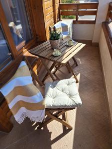 a wooden table and chairs on a balcony with a table at Cozy studio with balcony in 4-star hotel Saint Ivan Rilski, Bansko in Bansko