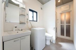 een witte badkamer met een toilet en een wastafel bij JASPER Waseda in Tokyo