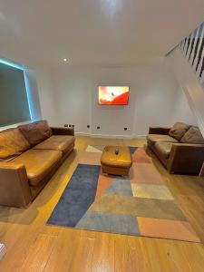 a living room with two couches and a table at South Cottage in Hardingstone