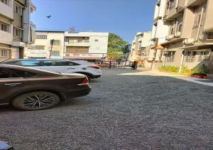 dos coches estacionados en un estacionamiento junto a los edificios en HOTEL CVR, en Nanded