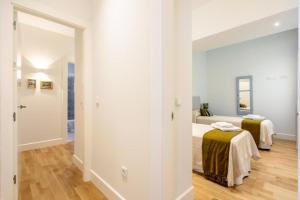 1 dormitorio con 2 camas y espejo en Magno Apartments Casa del Correo Mayor I en Sevilla