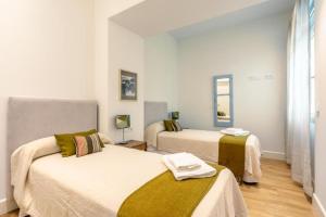 - une chambre avec 2 lits et une fenêtre dans l'établissement Magno Apartments Casa del Correo Mayor I, à Séville