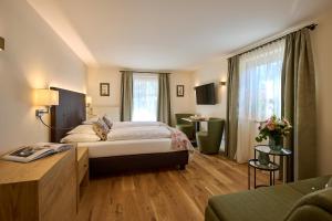 a hotel room with a bed and a desk at Hotel Garni Schneider in Lech am Arlberg