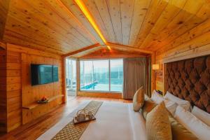 Anantam Resort & Spa في كاساولى: غرفة معيشة مع أريكة ونافذة كبيرة