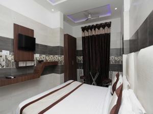 a bedroom with a bed and a flat screen tv at Collection O Hotel RV Palace in Agra