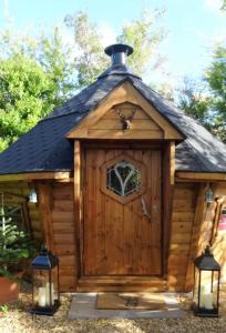 a large wooden dog house with a roof at We have a choice of 1 of 3 separate rooms in our home, a double room upstairs, a large double with en suite downstairs or a bar b q lodge in the garden with its own toilet and shower facilities please book the room you would like to stay in in Portishead