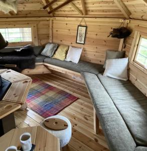 Setusvæði á We have 2 rooms to offer at our home - there is a very large downstairs bedroom with ensuite and a beautiful bar b q lodge that sleeps 4 with its own separate toilet and shower facility opposite the lodge