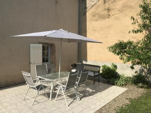 un tavolo e sedie sotto un ombrellone su un patio di Gites de la gartempe : saint-remy a Saint-Rémy-en-Montmorillon