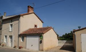 una piccola casa bianca con una recinzione bianca di Gites de la gartempe : saint-remy a Saint-Rémy-en-Montmorillon