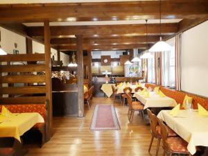 ein Esszimmer mit weißen Tischen und Stühlen in der Unterkunft Hotel Goldbächel in Wachenheim an der Weinstraße