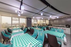 広州市にあるFeili International Hotelの緑と白のテーブルと椅子が備わるレストラン