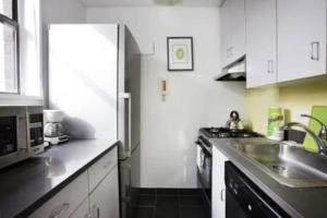 a kitchen with a stainless steel refrigerator and a sink at Beautiful 3 BR Apartment in Manhattan in New York