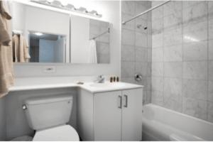 a bathroom with a toilet and a sink and a tub at Beautiful 3 BR Apartment in Manhattan in New York