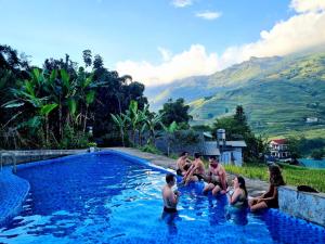 un grupo de personas sentadas en una piscina en Tavan Chopai Homestay, en Sa Pa