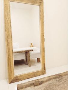 a mirror in a room with a table and a bench at Classic Local House Grenceng in Denpasar