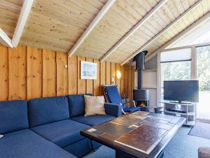ein Wohnzimmer mit einem blauen Sofa und einem Tisch in der Unterkunft 7 person holiday home in Bl vand in Ho